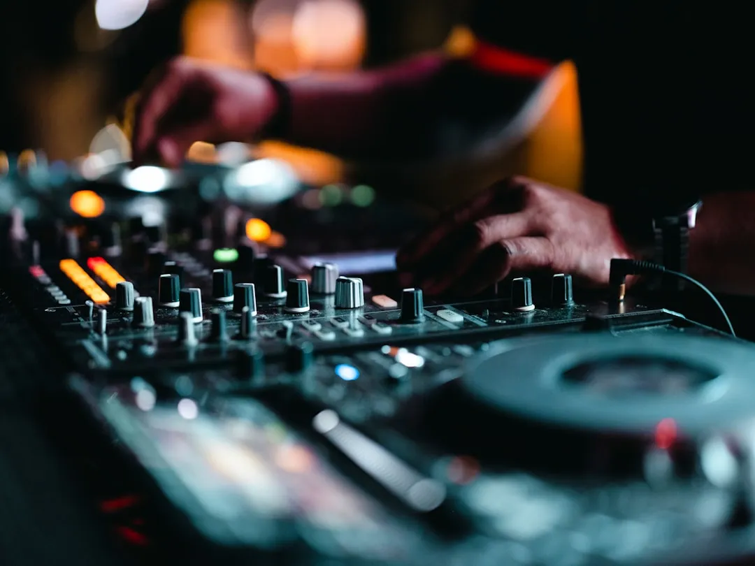 DJ mixing on a controller as an equalizer pulses to the beat