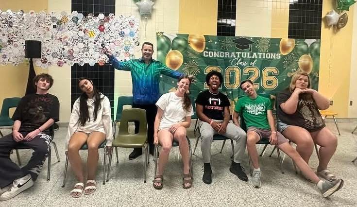 Joe Hussey with student volunteers in front of a Class of 2026 banner